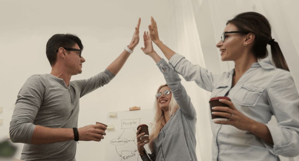 Equipo de trabajo de alto rendimiento festejando un avance muy importante gracias a las dinámicas del agility coaching.